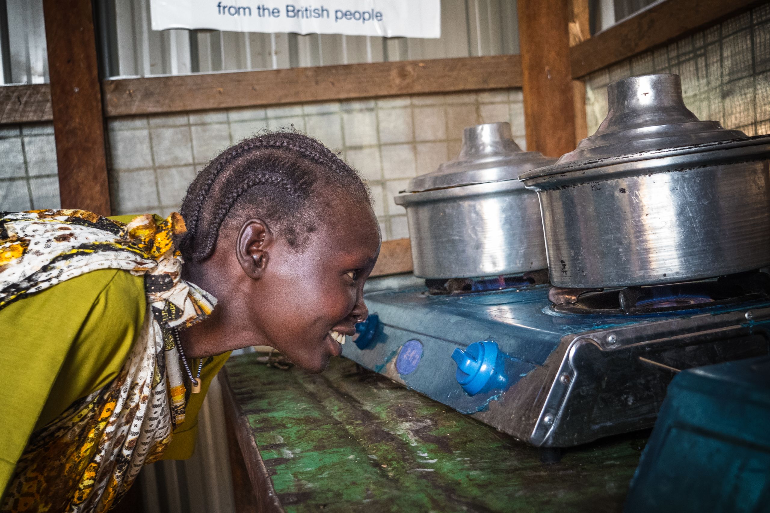 Sarah Pamed checking the gas flame from a biogas plant in Malakal refugee camp, South Sudan.